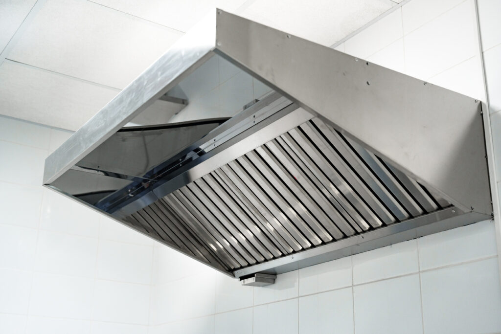 A stainless steel kitchen hood vent above a stove