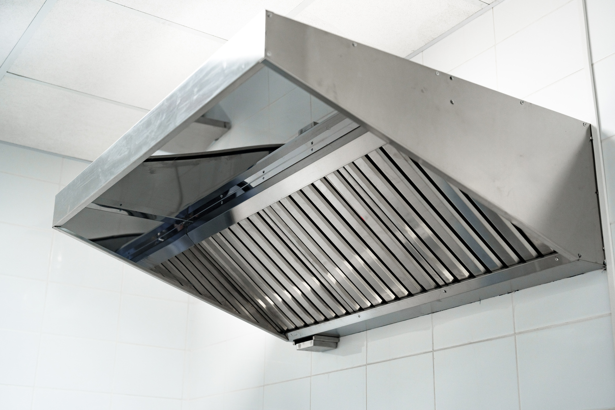 A stainless steel kitchen hood vent above a stove