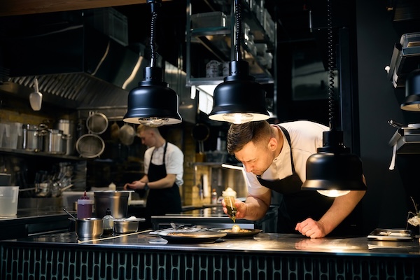 A chef working at a spotless prep table after using high-quality restaurant cleaning products
