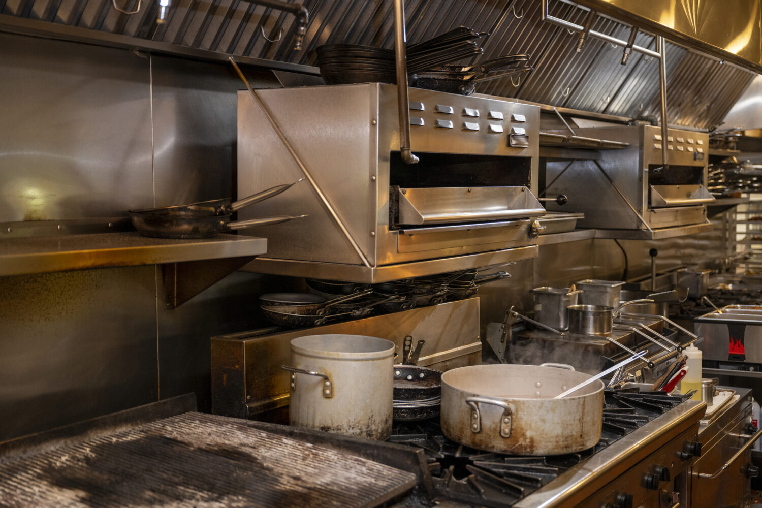 Dirty pots, pans, and other kitchen equipment in a commercial kitchen