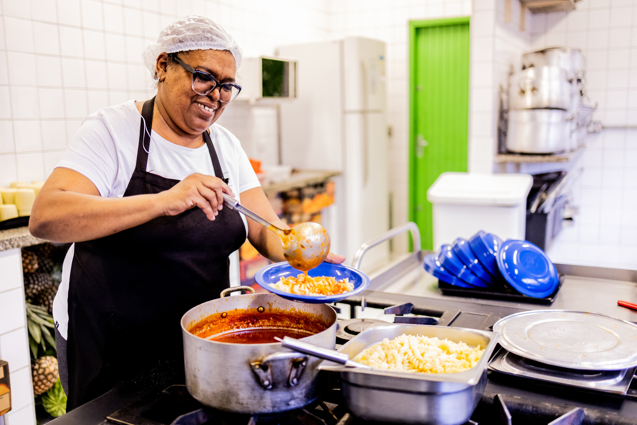 School cook preparing lunch in the kitchen at school