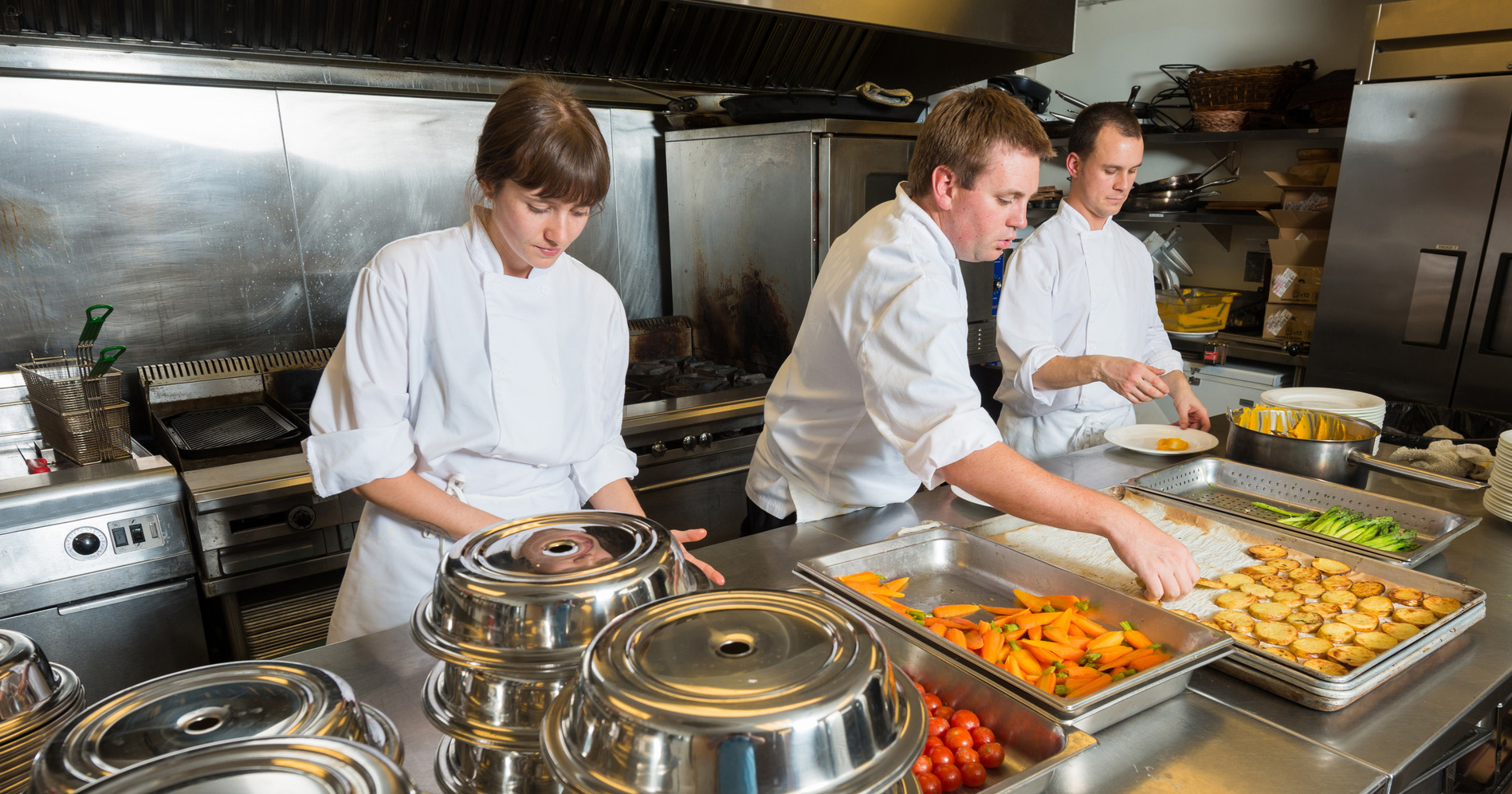 Chefs in hotel kitchen plating room service orders