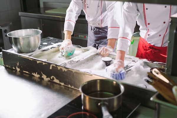 Sanitary day in the restaurant with multiple staff members cleaning, leaving operators wondering how to lower restaurant labor costs using automation