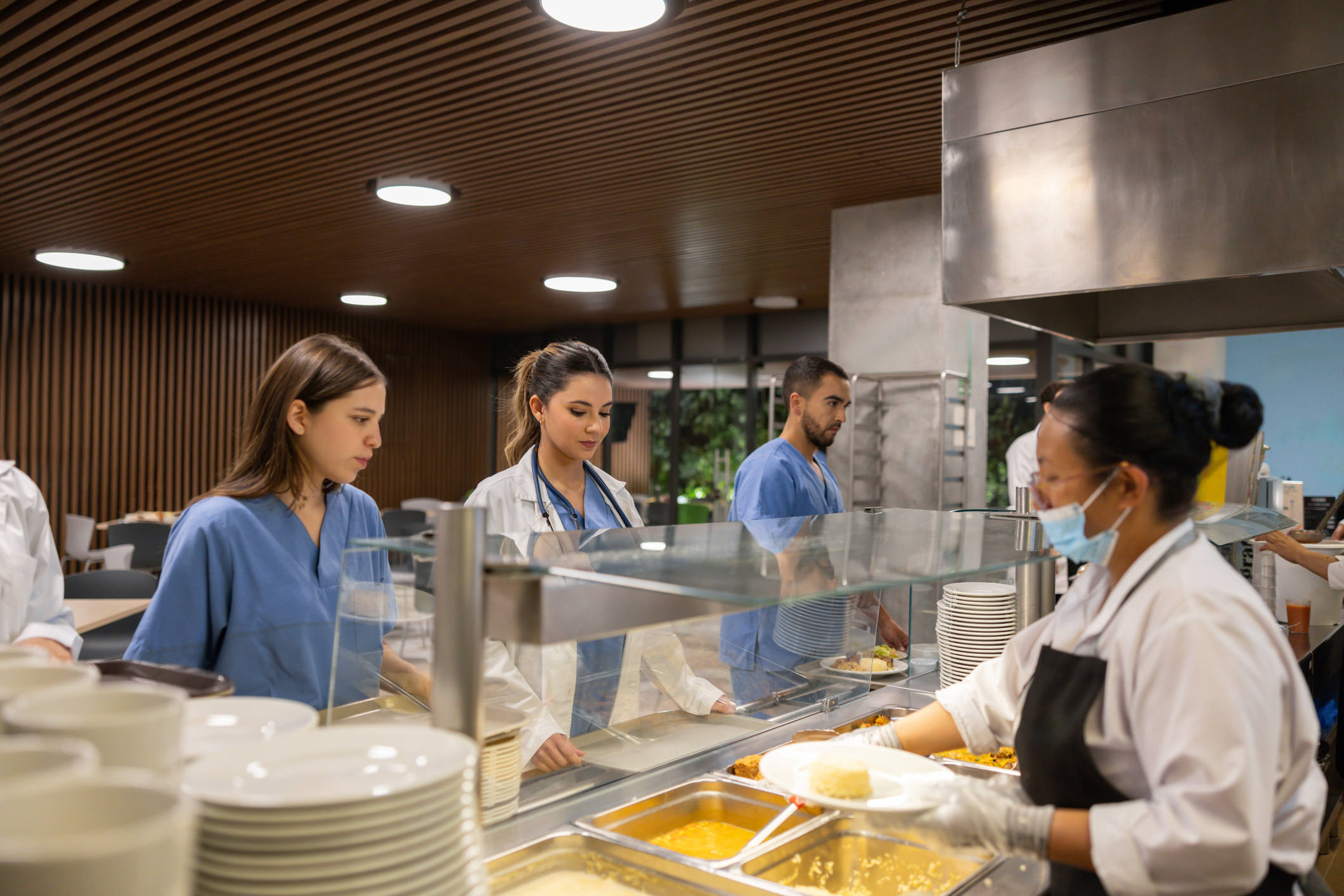 Group of doctors having lunch in the hospital's cafeteria at the buffet