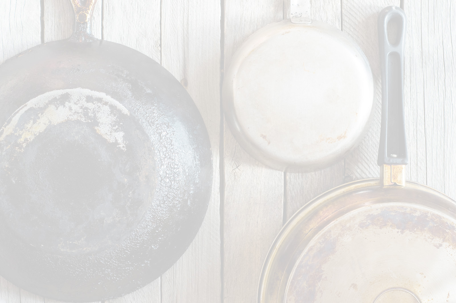 Dirty carbonized pans hanging on a wooden wall