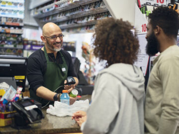 A young couple shopping in a small convenience store.